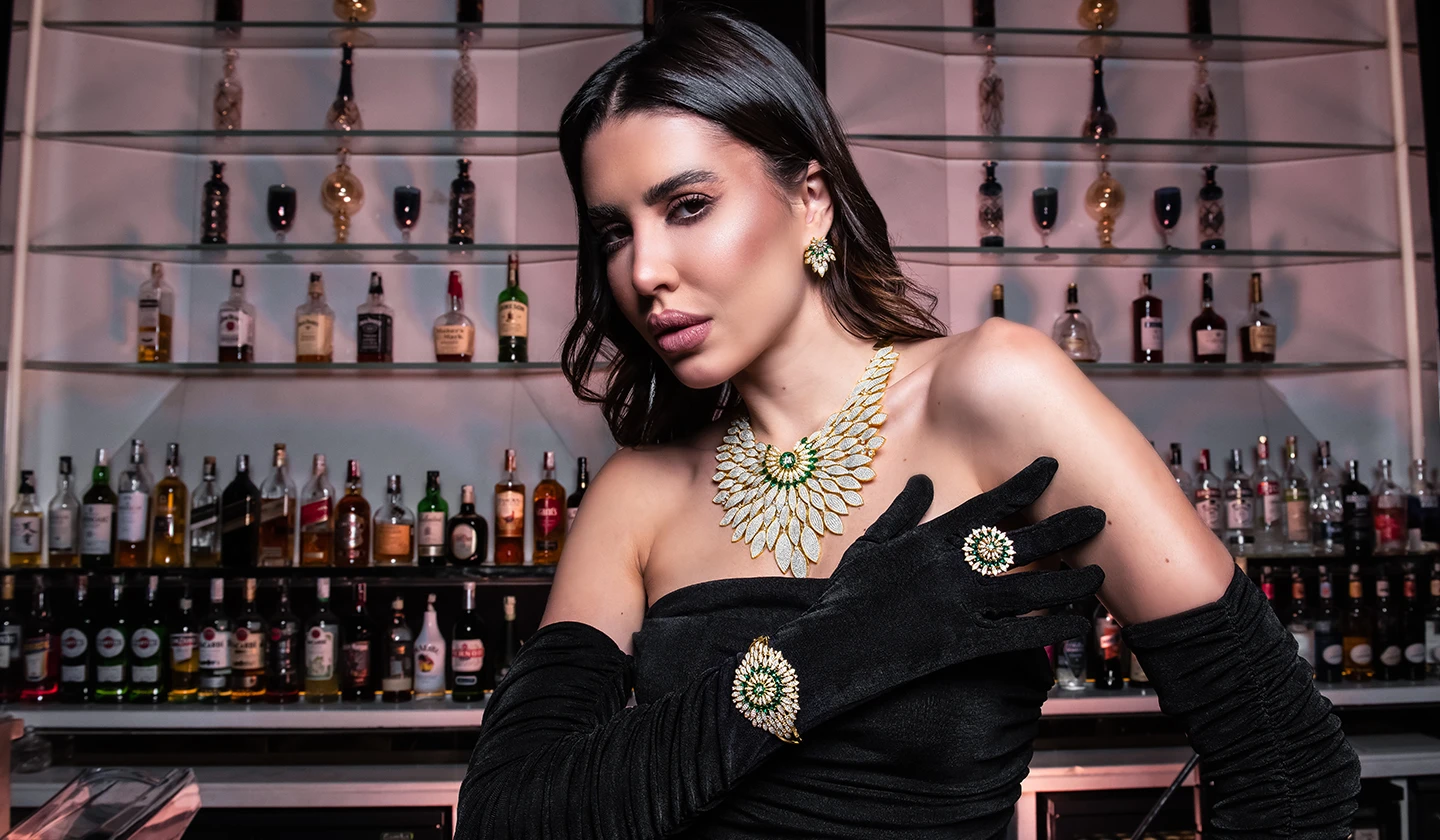 Model wearing a diamond and emerald necklace, earrings, and rings from the 2026 collection